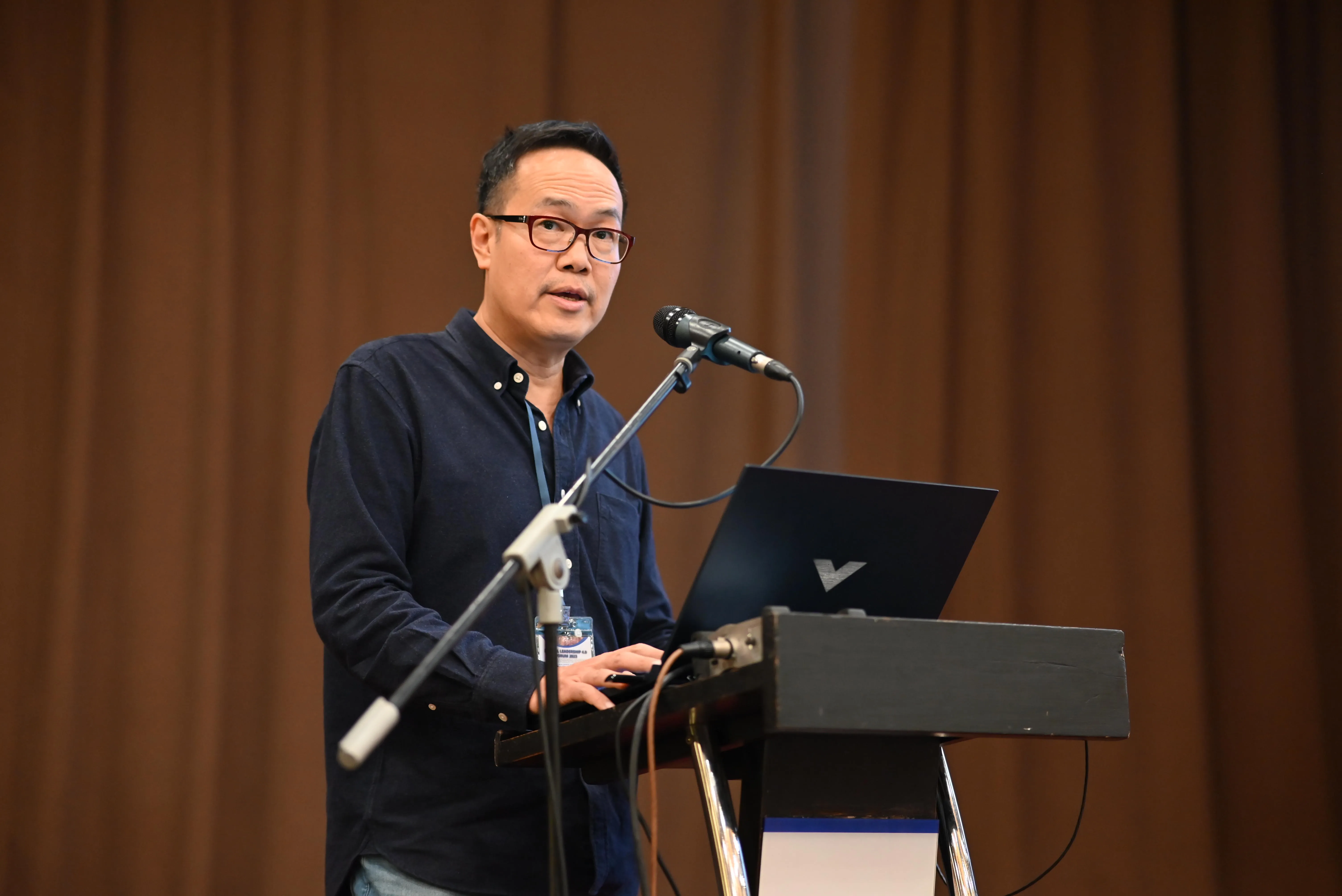 Peter Kua delivering a keynote at a leadership forum.