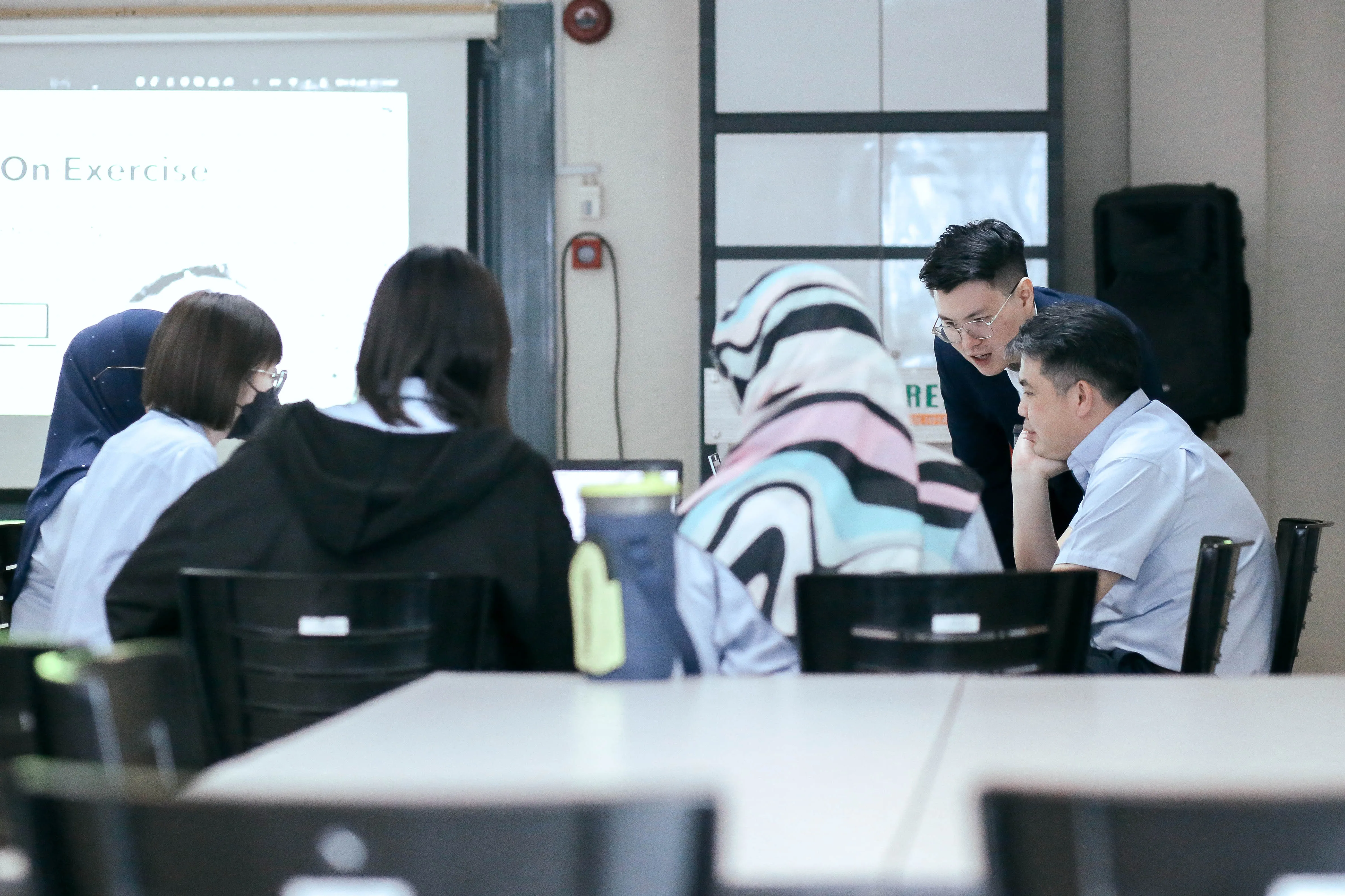Trainer coaching a small group through an AI exercise during a working session.