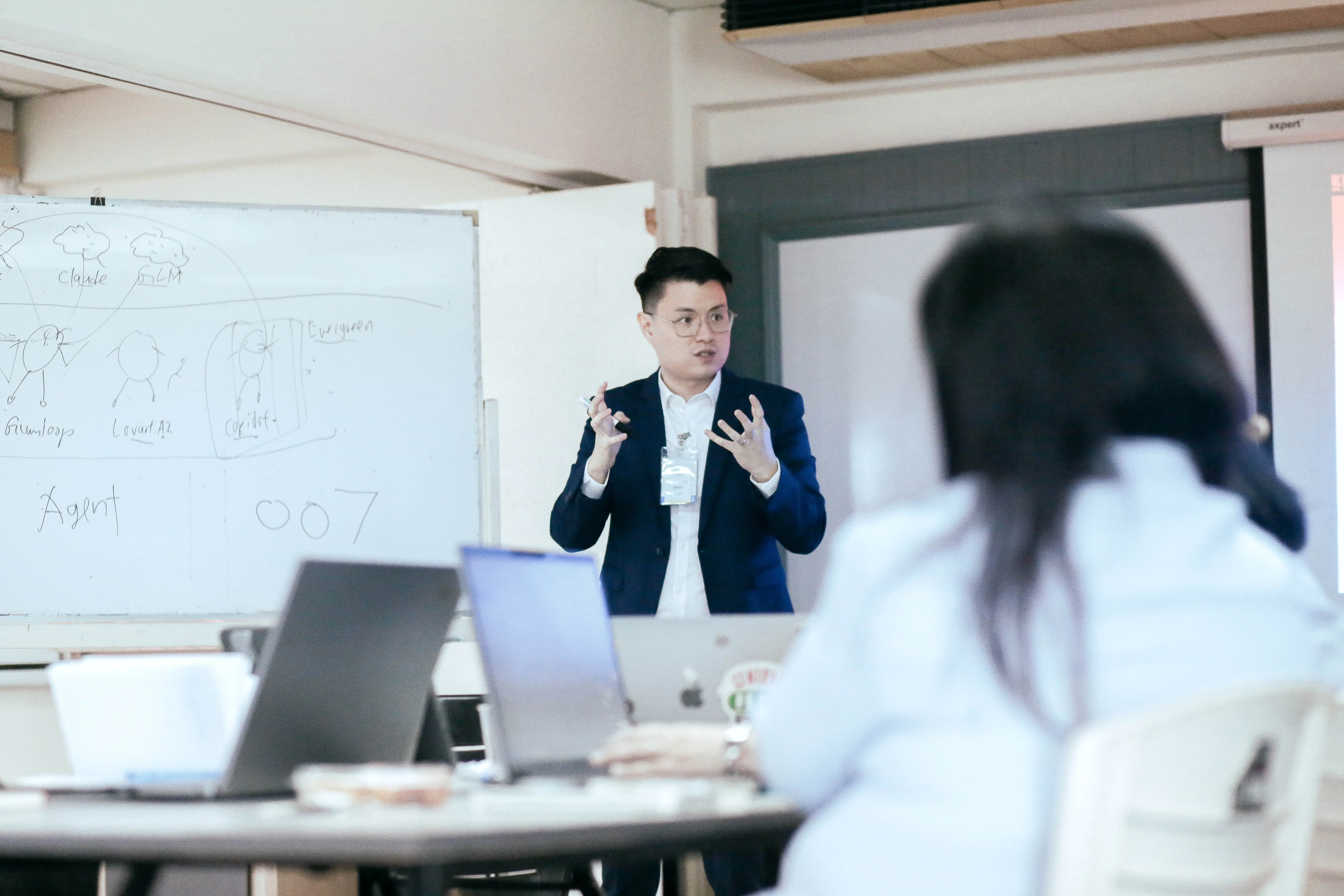 Trainer explaining an AI agent workflow at the whiteboard.